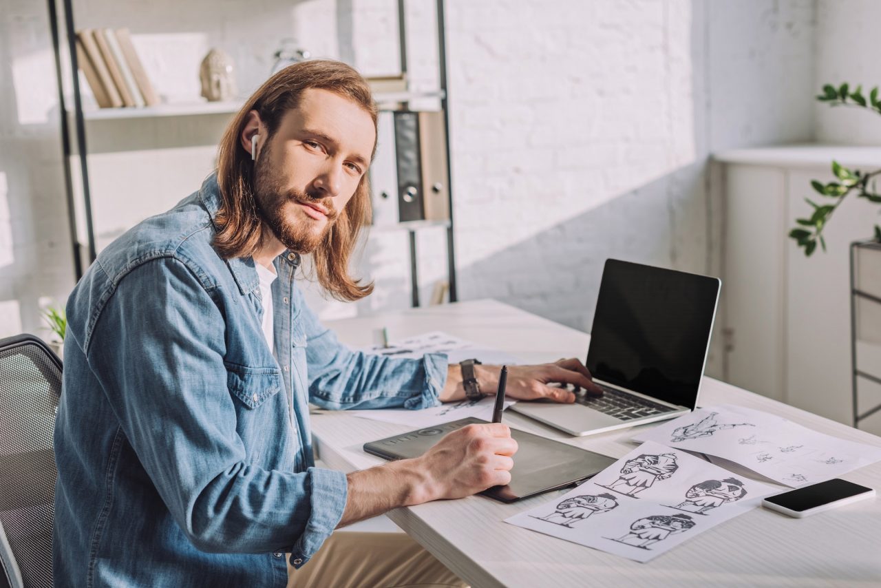 bearded-of-animator-in-wireless-earphones-near-gadgets.jpg